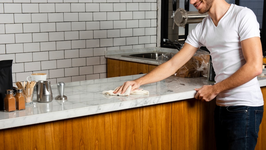 Man wiping the worktop with the cloth